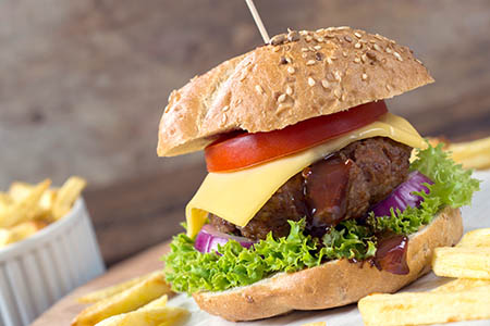 Cheeseburger with beef meat and french fries on the wooden table